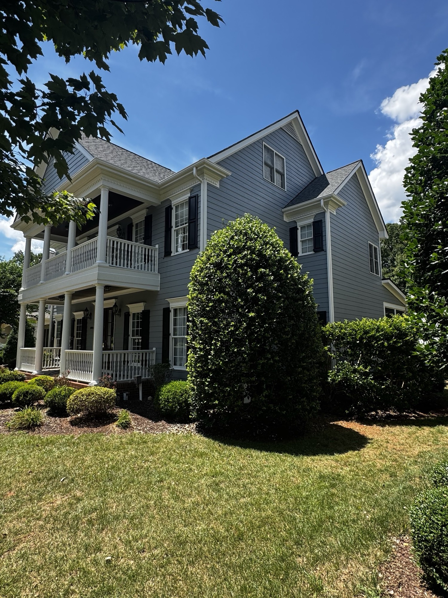 A two-story home in soft slate-grey with white porch detail.